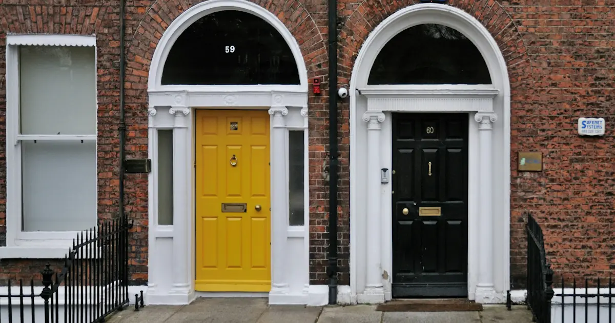 Red-brick row houses along a quiet residential street in Dublin on an overcast day.