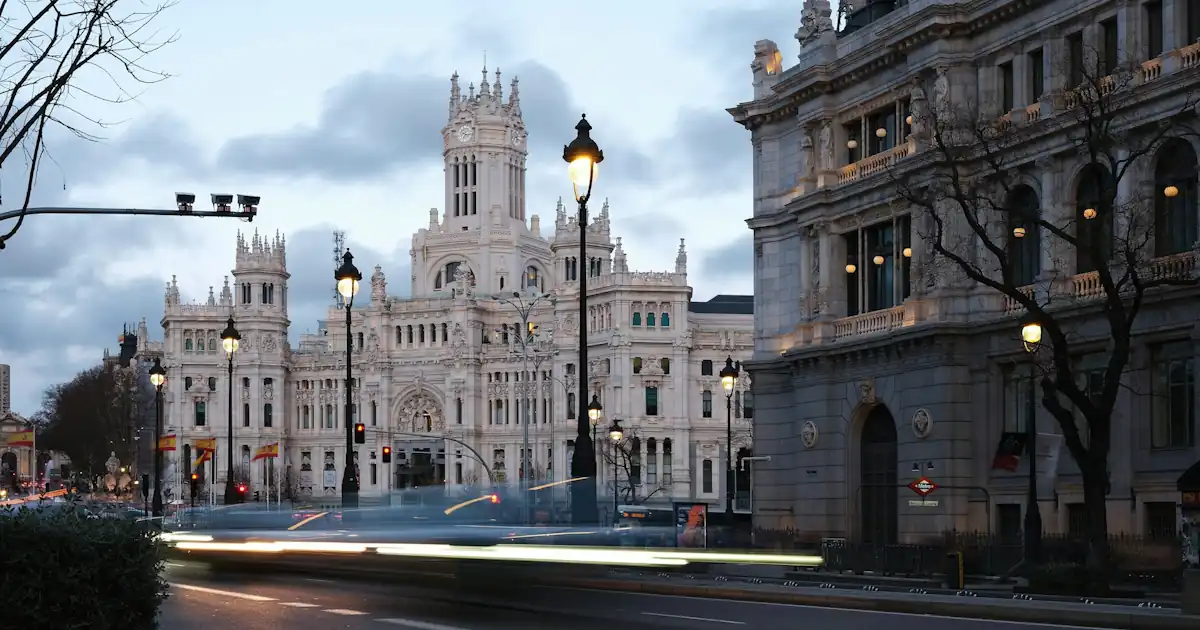 Tree-lined street and buildings in central Madrid in the evening